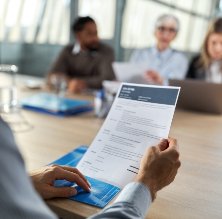 person holding a resume at a job interview